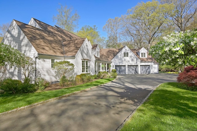 view of side of home featuring driveway and a shingled roof