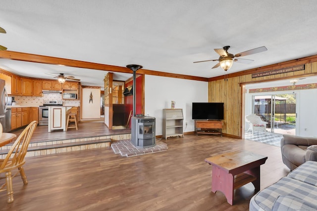 7 Sharren Ln, Enfield, CT 06082 - living area featuring wood walls, a wood stove, dark wood-style floors, a ceiling fan, and baseboards