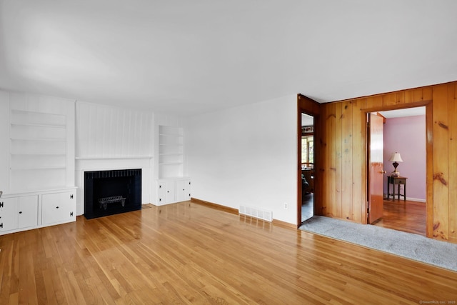 7 Sharren Ln, Enfield, CT 06082 - unfurnished living room featuring wood finished floors, visible vents, built in features, wooden walls, and baseboards