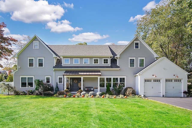 view of front of house with aphalt driveway, an attached garage, a front lawn, and a shingled roof