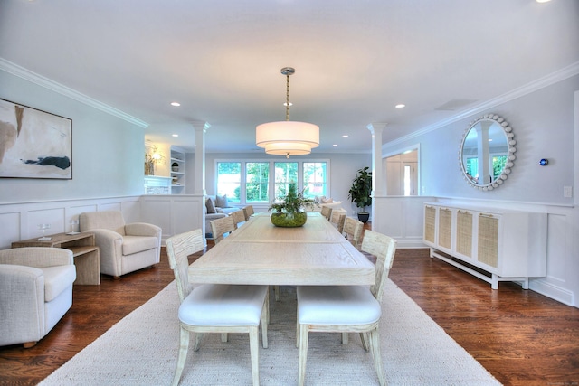 dining area with ornamental molding, dark wood-type flooring, a decorative wall, and ornate columns