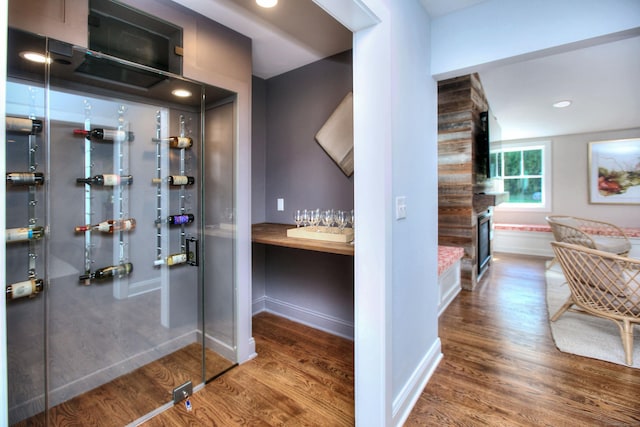 wine room with baseboards, a fireplace, and wood finished floors