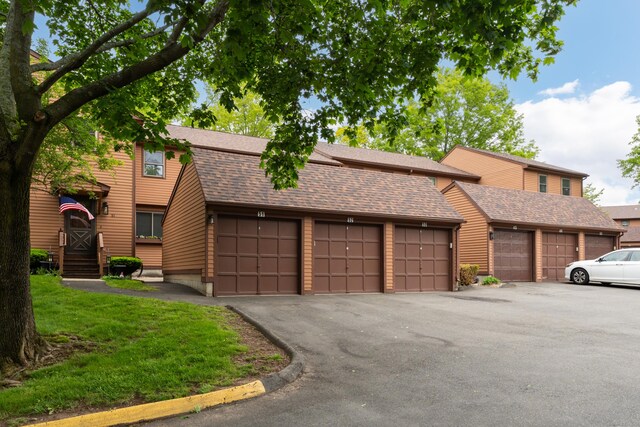 53 Cedar Knolls Dr Unit 53, Branford, CT 06405 - view of front facade featuring community garages and a shingled roof
