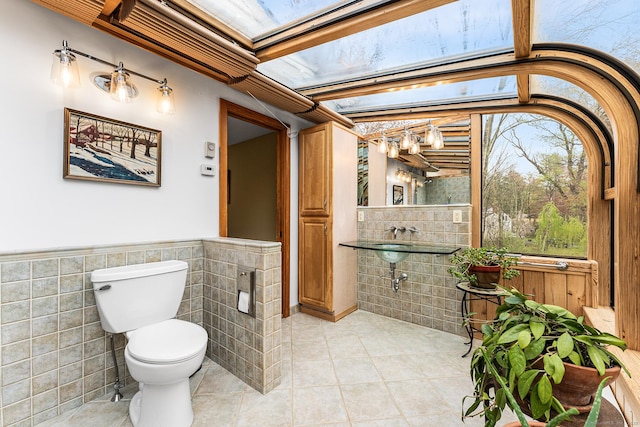 16 Howes Ln, Redding, CT 06896 - half bathroom featuring tile walls, tile patterned flooring, and wainscoting