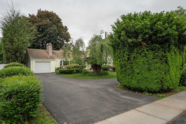 955 N Main St, West Hartford, CT 06117 - obstructed view of property featuring driveway, a chimney, and a garage