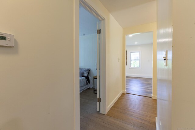 corridor featuring baseboards and hardwood / wood-style floors