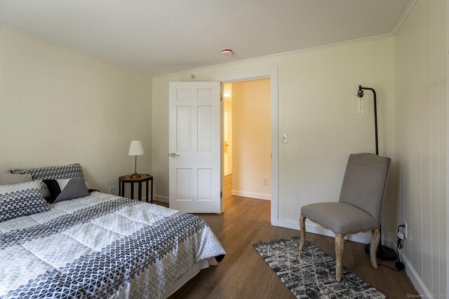 bedroom featuring crown molding, baseboards, and dark wood finished floors