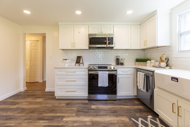 kitchen with tasteful backsplash, dark wood finished floors, light countertops, stainless steel appliances, and white cabinetry