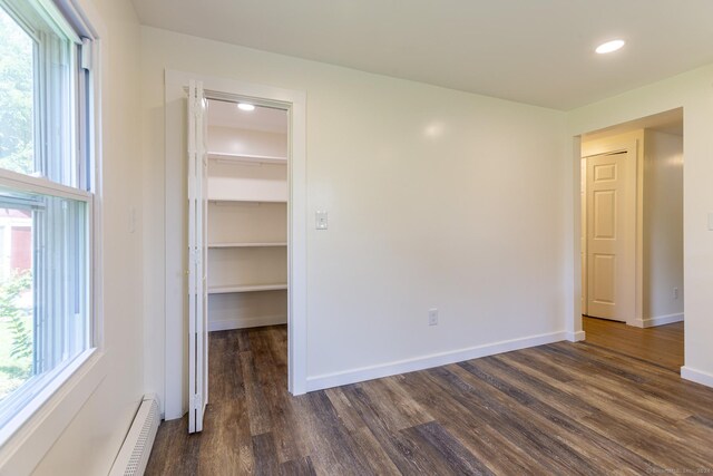 unfurnished room with recessed lighting, plenty of natural light, and dark wood finished floors