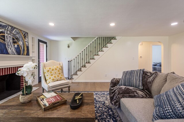 living area featuring stairway, arched walkways, recessed lighting, and wood finished floors