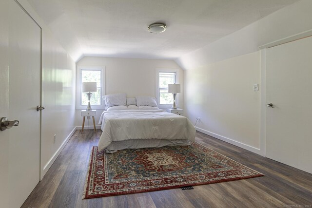 bedroom with baseboards, vaulted ceiling, and wood finished floors