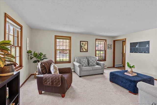 living room with plenty of natural light, a textured ceiling, baseboard heating, and light carpet
