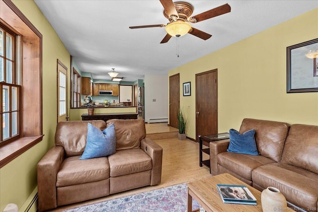 living room featuring baseboards, ceiling fan, baseboard heating, a baseboard radiator, and light wood finished floors