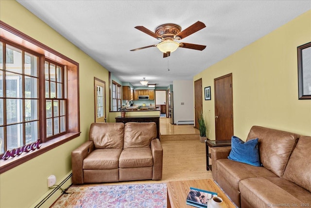 living area featuring a baseboard radiator, a baseboard heating unit, ceiling fan, and a wealth of natural light