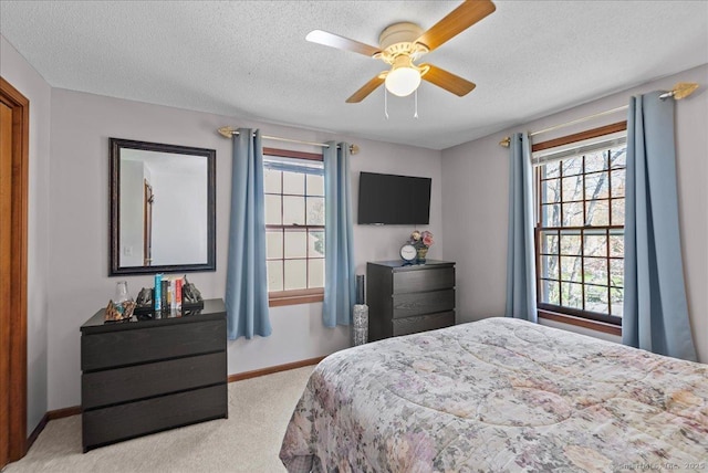 bedroom with multiple windows, carpet flooring, and a textured ceiling