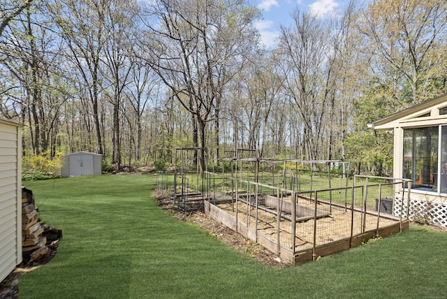 view of yard featuring a storage unit, an outbuilding, and a vegetable garden