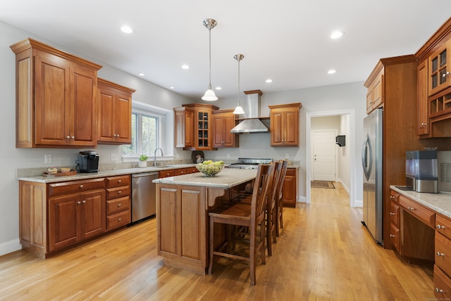 kitchen featuring appliances with stainless steel finishes, a kitchen island, brown cabinets, and light wood-style floors