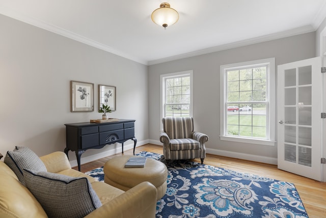 sitting room featuring ornamental molding, baseboards, and wood finished floors