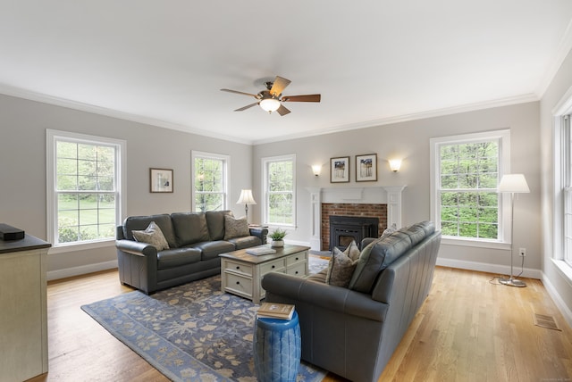 living room with visible vents, ceiling fan, light wood-style flooring, crown molding, and baseboards