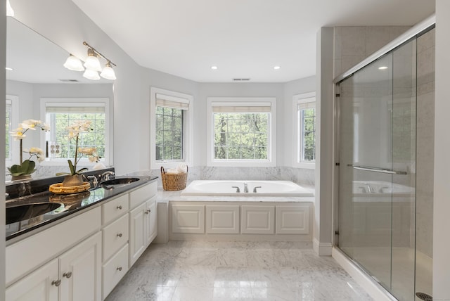 full bathroom featuring a stall shower, a wealth of natural light, and a bath
