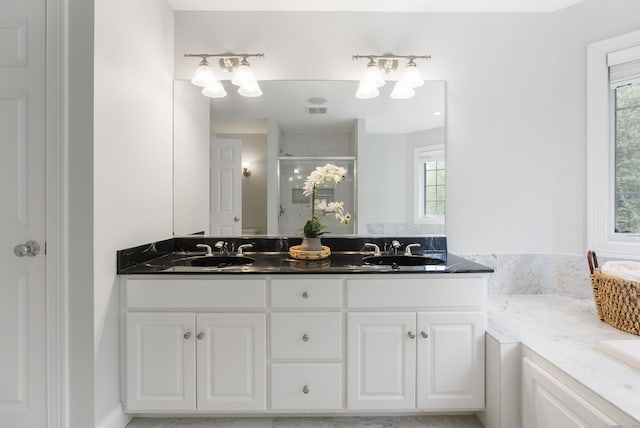 full bath featuring plenty of natural light, a shower stall, and a sink