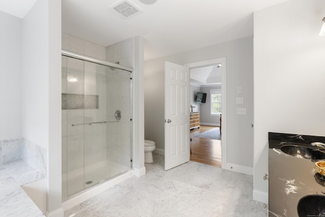 full bath with a stall shower, toilet, a sink, and visible vents