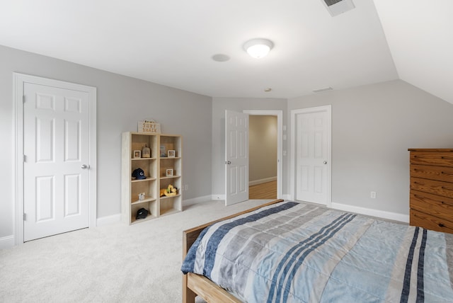 carpeted bedroom featuring lofted ceiling, baseboards, and visible vents