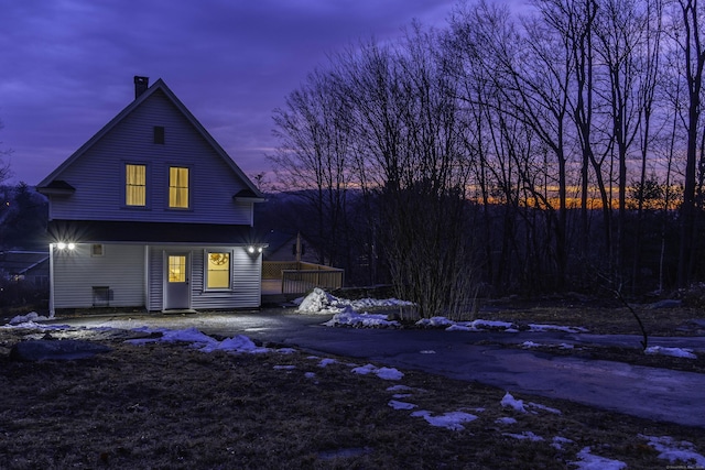 rear view of house with a wooden deck and a chimney
