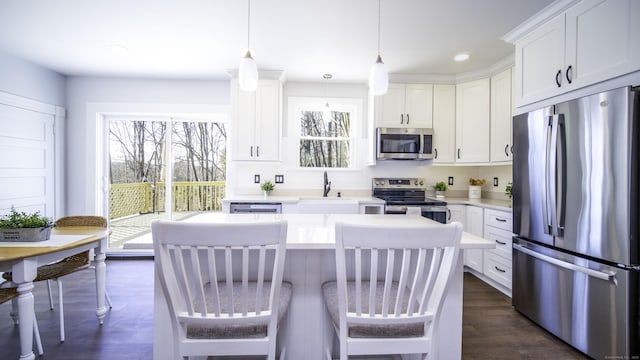 kitchen with light countertops, appliances with stainless steel finishes, plenty of natural light, and a sink