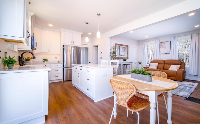 kitchen featuring light countertops, freestanding refrigerator, white cabinetry, and a sink