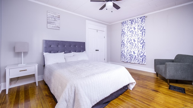 bedroom featuring crown molding, wood-type flooring, a ceiling fan, baseboards, and visible vents