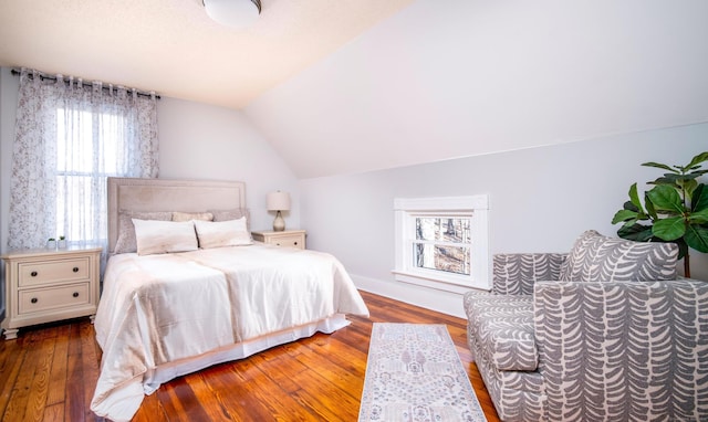 bedroom featuring wood finished floors and lofted ceiling
