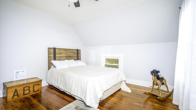 bedroom with ceiling fan, visible vents, wood finished floors, baseboards, and lofted ceiling
