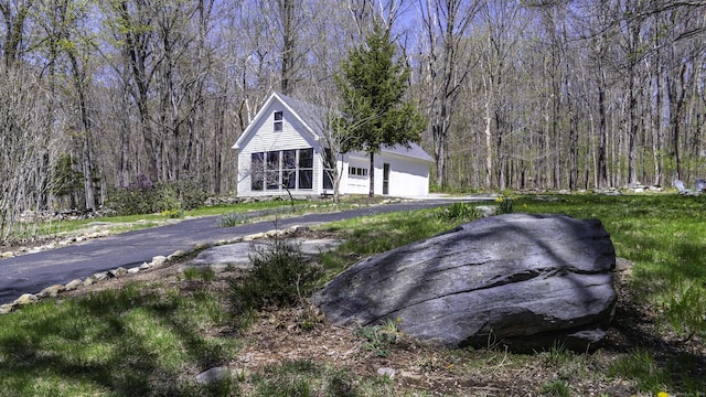 view of front of property featuring a wooded view