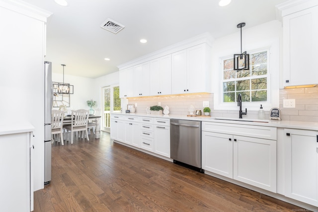 kitchen featuring a sink, light countertops, stainless steel dishwasher, visible vents, and dark wood-style floors