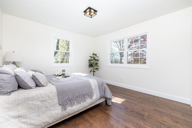 bedroom featuring baseboards and dark wood finished floors
