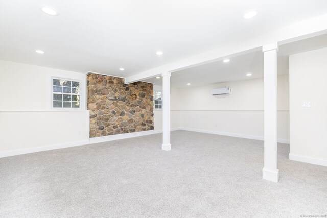below grade area with carpet floors, recessed lighting, baseboards, and an AC wall unit