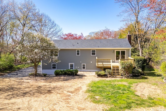 back of property featuring a chimney, driveway, a deck, and stairway
