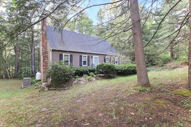 view of front of house with roof with shingles and a chimney