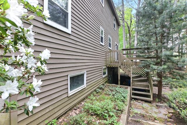 view of side of home with stairs and a deck
