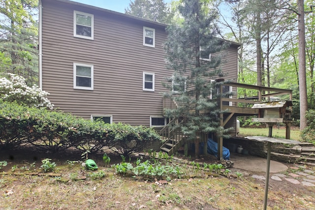 view of property exterior with stairway and a deck