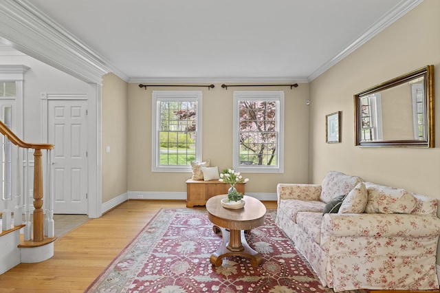 sitting room featuring crown molding, baseboards, stairs, and light wood-type flooring