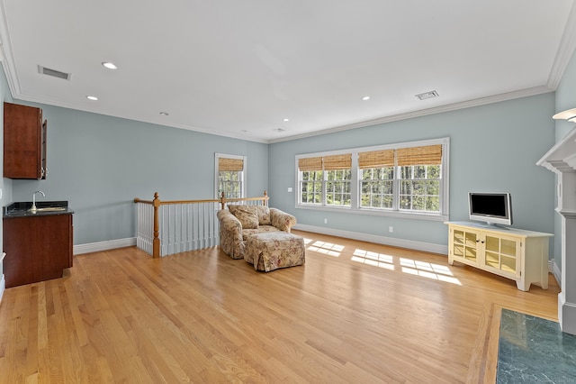 sitting room with visible vents, ornamental molding, baseboards, and light wood-type flooring