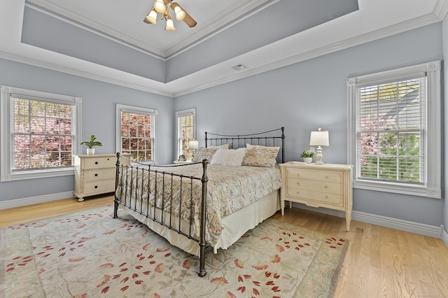 bedroom featuring baseboards, visible vents, multiple windows, and light wood-style floors