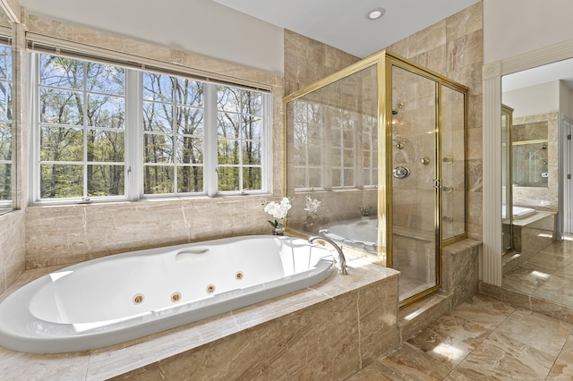 bathroom with plenty of natural light, marble finish floor, a whirlpool tub, and a stall shower