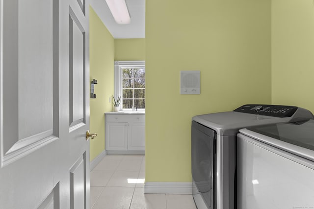 laundry room featuring baseboards, laundry area, washing machine and dryer, and light tile patterned floors