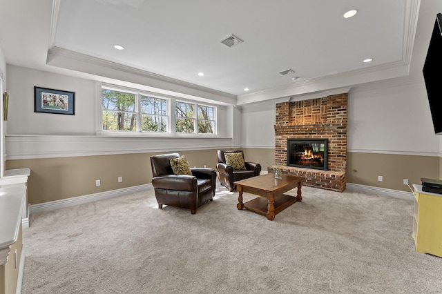carpeted living room featuring crown molding, a tray ceiling, a brick fireplace, and visible vents