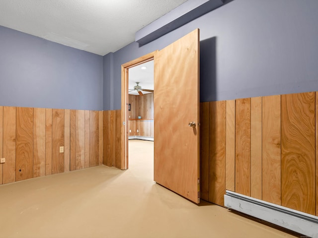 29 Washington Dr, Groton, CT 06340 - empty room with concrete floors, a ceiling fan, wood walls, and baseboard heating