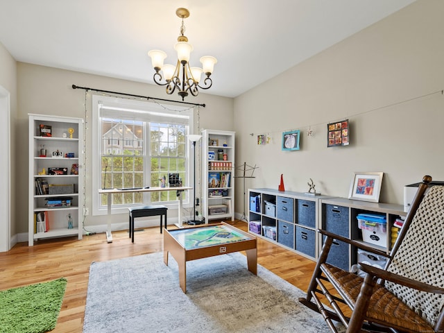rec room featuring a chandelier, wood finished floors, and baseboards