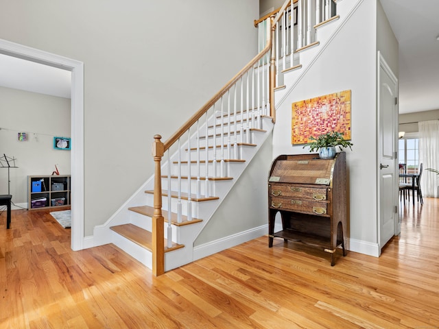 stairs featuring wood finished floors and baseboards